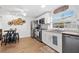 Kitchen with stainless steel appliances, a modern bar-style dining area, and decorative wall art at 5141 Mallet Dr, Port Richey, FL 34668