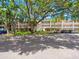 Exterior view of the building showing landscaping and cars in the parking lot at 821 Patricia Ave # 202, Dunedin, FL 34698