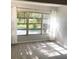 Sun-drenched living room with scenic views through large windows and sheer white curtains, showcasing wood-look floors at 821 Patricia Ave # 202, Dunedin, FL 34698