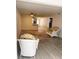 Open-concept living area with modern wood-look floors, complemented by woven chairs, leading into the kitchen at 821 Patricia Ave # 202, Dunedin, FL 34698