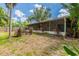 A view of the backyard that includes the covered porch and planting beds at 7814 34Th E Ct, Sarasota, FL 34243