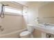 Clean bathroom with white tiled walls, a bathtub, and a pedestal sink at 7814 34Th E Ct, Sarasota, FL 34243