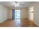 A main bedroom with neutral walls, a sliding glass door, ceiling fan, and adjoining bathroom at 7814 34Th E Ct, Sarasota, FL 34243