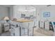 Bright open kitchen with breakfast bar, white appliances, and stylish backsplash, connecting to living area at 11923 Boynton Ln # B, New Port Richey, FL 34654
