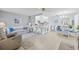 Bright and airy living room featuring neutral decor, tile flooring, and open-concept design to the kitchen at 11923 Boynton Ln # B, New Port Richey, FL 34654