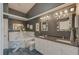 A bathroom featuring a tub with marble backsplash, double vanity, and decorative mirrors at 150 Brent Cir, Oldsmar, FL 34677