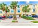 Charming townhouse exterior featuring a yellow facade, palm trees and private driveways at 150 Brent Cir, Oldsmar, FL 34677