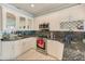 Modern kitchen featuring granite counters, stainless steel appliances, and wine rack at 150 Brent Cir, Oldsmar, FL 34677
