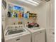 Bright laundry room with shelving and full-size, white washer and dryer at 150 Brent Cir, Oldsmar, FL 34677