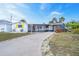 Charming single-story home with driveway, white exterior, screened porch, and lush landscaping at 456 Sandlewood Dr, Venice, FL 34293
