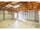Spacious garage with exposed rafters, block walls and concrete floors provides ample space for parking and storage at 456 Sandlewood Dr, Venice, FL 34293