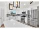 Well-lit kitchen featuring stainless steel appliances, quartz countertops, and ample storage space at 456 Sandlewood Dr, Venice, FL 34293