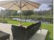 Comfortable outdoor seating area with umbrella offering a peaceful lake view and backyard landscape at 5150 San Palermo Dr, Bradenton, FL 34208