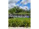 Lush backyard foliage and manicured lawn with a serene lake view providing a tranquil setting at 5150 San Palermo Dr, Bradenton, FL 34208