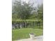 Beautiful backyard featuring a wrought iron fence bordering a lake and a young tree in a pot at 5150 San Palermo Dr, Bradenton, FL 34208