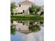 Back exterior view shows a large house with a patio set overlooking a beautiful serene lake at 5150 San Palermo Dr, Bradenton, FL 34208