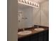 Bright bathroom with double sinks, framed mirror, and walk-in shower at 5150 San Palermo Dr, Bradenton, FL 34208