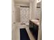 Bathroom featuring a dual sink vanity, white tile floors, and a shower/tub combo with a nautical-themed curtain at 5150 San Palermo Dr, Bradenton, FL 34208