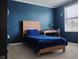Cozy bedroom featuring a wooden bed frame, blue walls and carpeted floors, creating a relaxing atmosphere at 5150 San Palermo Dr, Bradenton, FL 34208