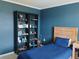 Cozy blue bedroom with a twin bed and built-in bookcase at 5150 San Palermo Dr, Bradenton, FL 34208
