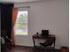 Modern home office space with dark wood floors, a window view, and comfortable seating at 5150 San Palermo Dr, Bradenton, FL 34208