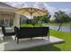 Inviting patio featuring comfortable seating, a shady umbrella, and a serene lake view at 5150 San Palermo Dr, Bradenton, FL 34208