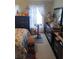 A quaint bedroom with floral curtains, personal touches, and a stationary exercise bike near the window at 6640 121St Ave # 1, Largo, FL 33773
