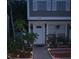 Charming townhome showcasing a well-manicured front yard with potted plants and walkway lights at 6640 121St Ave # 1, Largo, FL 33773