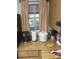 Kitchen counter featuring a window with tan curtains and various kitchen appliances at 6640 121St Ave # 1, Largo, FL 33773