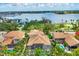 Aerial view of the property, showcasing the tile roof, screened-in pool, landscaping and proximity to the water at 811 Laguna Dr, Venice, FL 34285