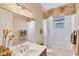 Bathroom featuring a bathtub, a vanity with storage, and a decorative mirror at 811 Laguna Dr, Venice, FL 34285