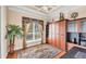 Cozy bedroom with a tray ceiling, large window, and built-in wood cabinets for storage at 811 Laguna Dr, Venice, FL 34285