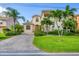 Beautiful two-story home with a balcony, manicured lawn, and a brick driveway at 811 Laguna Dr, Venice, FL 34285