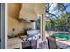 Built-in outdoor kitchen with stainless steel grill, sink, and counter space, perfect for outdoor entertaining by the pool at 811 Laguna Dr, Venice, FL 34285