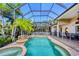 The screened in-ground pool features an attached hot tub and waterfall feature, and has lush landscaping at 811 Laguna Dr, Venice, FL 34285