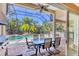 A screened-in patio offers outdoor dining with views of the pool, spa, and lush landscaping at 811 Laguna Dr, Venice, FL 34285