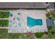 Aerial view of a swimming pool surrounded by lounge chairs, palm trees, and green landscaping at 9860 62Nd N Ter # 1047, St Petersburg, FL 33708