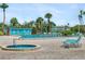 Community pool area featuring a heated spa, lounge chairs, and well-maintained landscaping at 9860 62Nd N Ter # 1047, St Petersburg, FL 33708