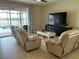 Living room boasts tile floors, two recliners, and a view of the screened pool area at 13642 Newport Shores Dr, Hudson, FL 34669