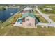 Aerial view of a waterfront home with a pool and spa, nestled on a canal at 15340 Alsask Cir, Port Charlotte, FL 33981