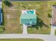 Aerial view of a backyard with a pool, spa, and green roof of the home at 15340 Alsask Cir, Port Charlotte, FL 33981
