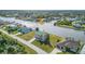 Aerial view of a waterfront home with a pool and canal access in a neighborhood at 15340 Alsask Cir, Port Charlotte, FL 33981