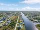 Wide aerial view showing a waterfront home in a community with canals at 15340 Alsask Cir, Port Charlotte, FL 33981