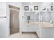 Bright bathroom featuring a glass-enclosed shower, white vanity with large mirrors, and decorative artwork at 15340 Alsask Cir, Port Charlotte, FL 33981