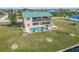 Aerial view of a two-story home with a pool, hot tub, and well-manicured lawn, offering a luxurious outdoor experience at 15340 Alsask Cir, Port Charlotte, FL 33981