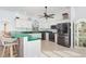Spacious kitchen with white cabinetry, modern stainless steel appliances, and a breakfast bar with wicker stools at 15340 Alsask Cir, Port Charlotte, FL 33981