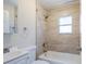 Well-lit bathroom features a shower-tub combination, tile walls, a window and modern fixtures at 1769 Dayton S St, St Petersburg, FL 33712