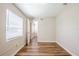 Empty bedroom with window, door, and hall access showing wood-look floors at 1769 Dayton S St, St Petersburg, FL 33712