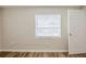 Bare bedroom with wood-look floors, window with blinds, and an interior white door at 1769 Dayton S St, St Petersburg, FL 33712