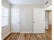 Unfurnished bedroom features wood-look floors, window with blinds, and doorway view at 1769 Dayton S St, St Petersburg, FL 33712